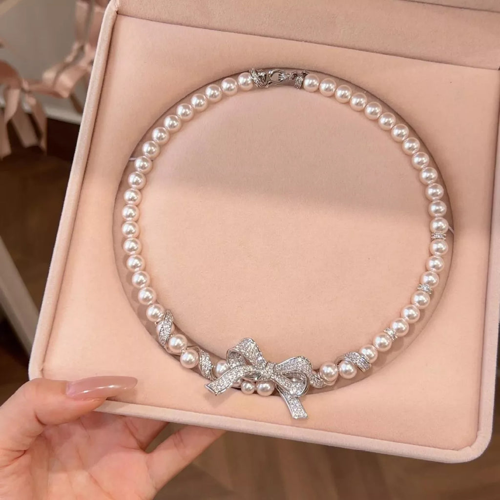 Elegant pearl necklace from Shopimist featuring a delicate bow pendant, perfect for stylish and sophisticated accessories.