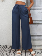 Women’s high-waisted wide-leg drawstring pants in soft, breathable viscose, shown in a relaxed fit with a drawstring waist.