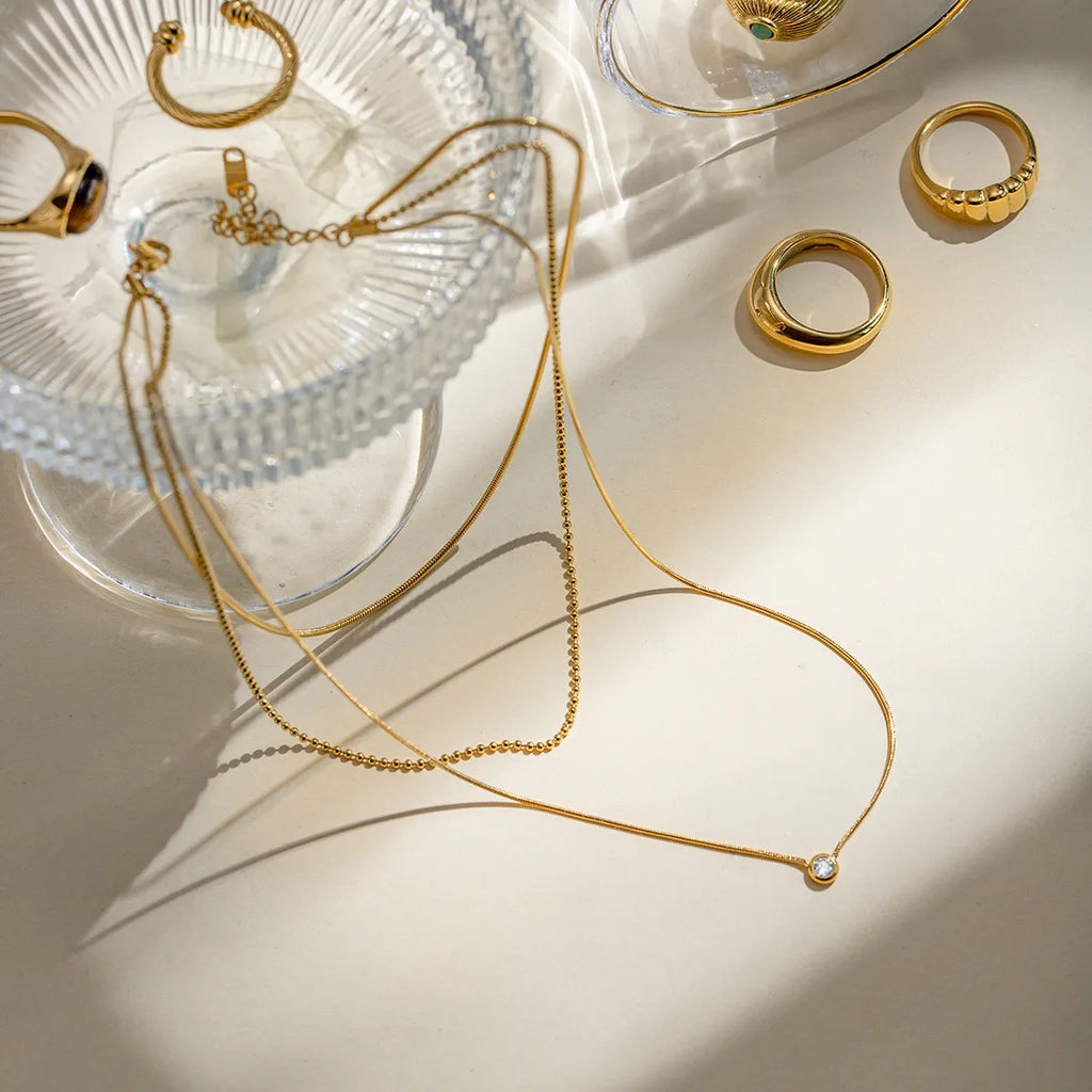 18K gold-plated layered necklace with delicate chains and small pendant, showcasing elegant jewelry design.