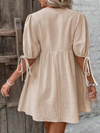 Cotton V-neck tie-front mini dress with puff sleeves, trendy and lightweight, perfect for casual or summer wear.
