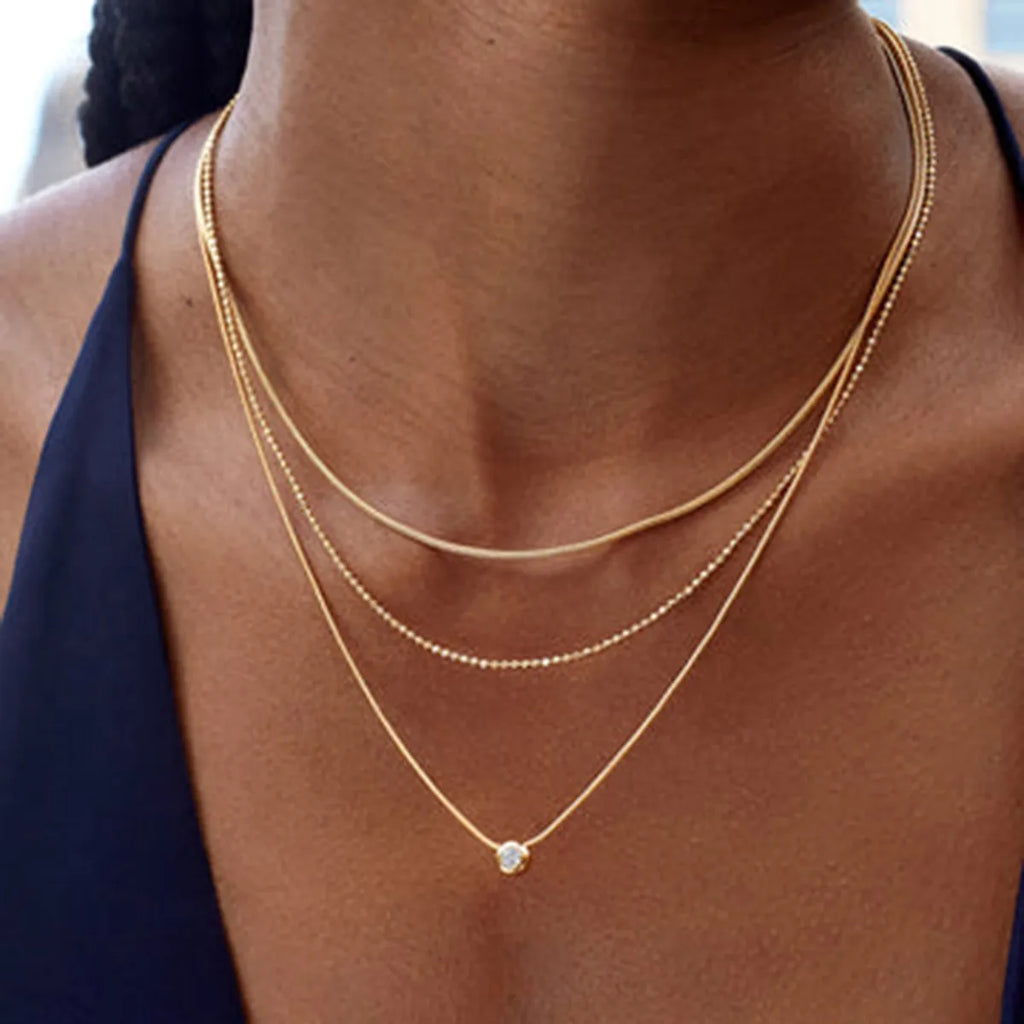 18K gold-plated layered necklace with delicate chains and small pendant, showcasing elegant jewelry design.