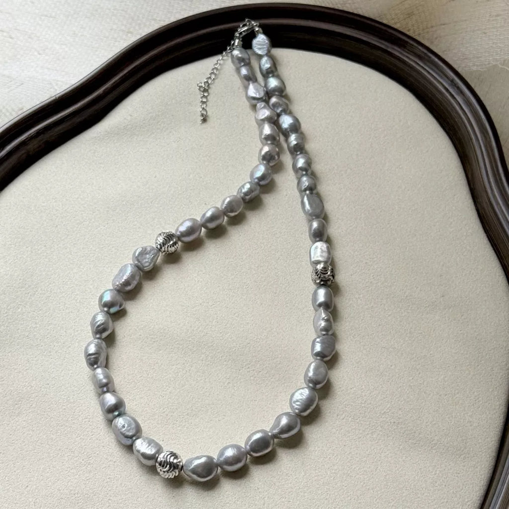 Pearl choker necklace by Shopimist featuring a string of white pearls on a delicate black cord.