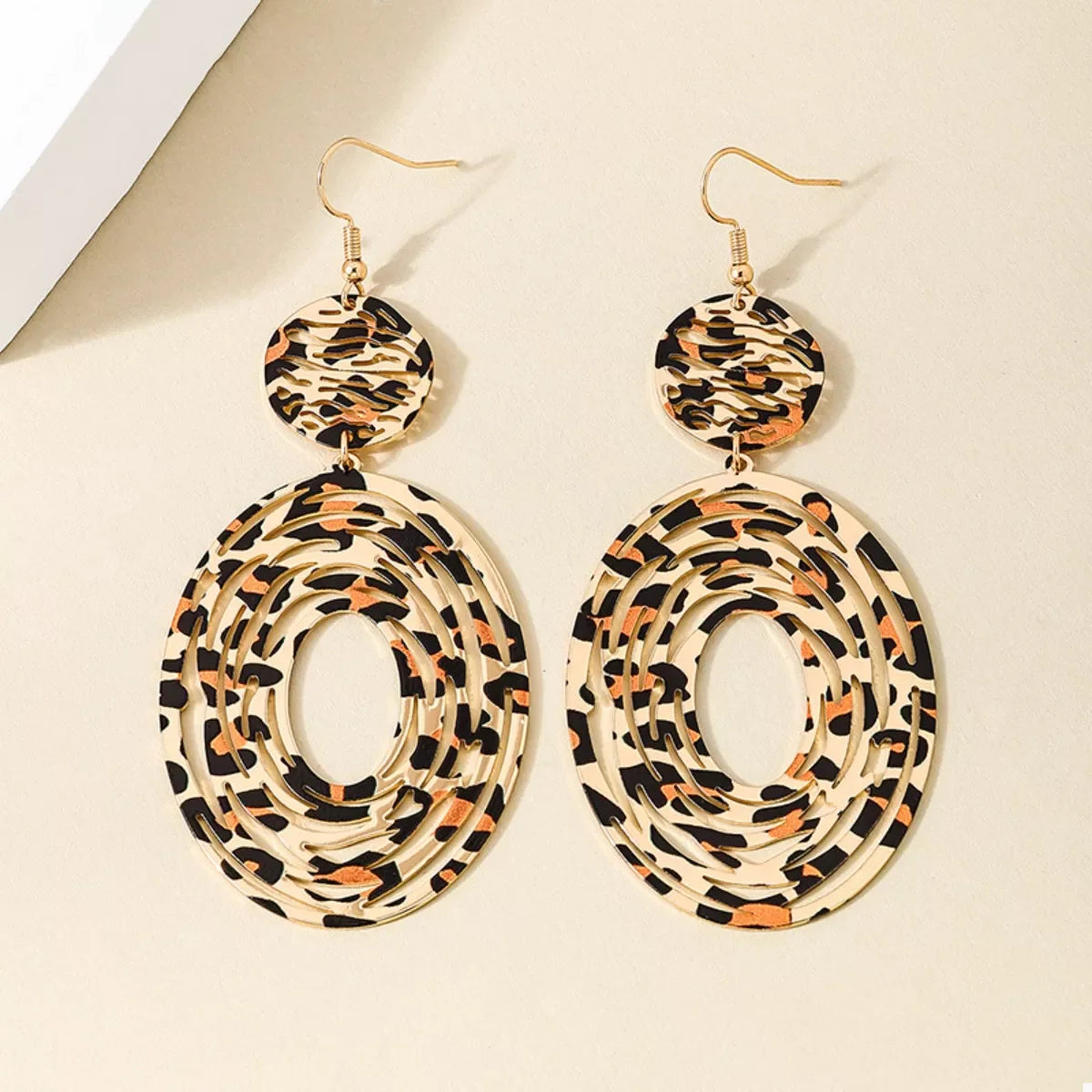 Leopard print dangle earrings from Plush Fashion Hub featuring gold hooks and bold animal print design.