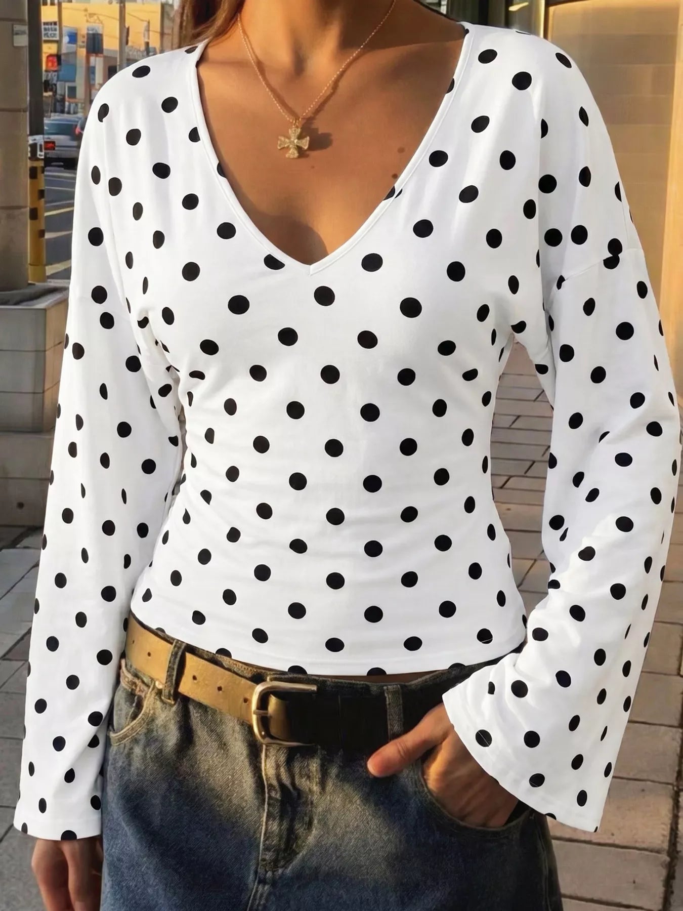 Polka dot V-neck long sleeve T-shirt by Plush Fashion Hub, featuring a black and white polka dot pattern and fitted design.