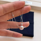 Planet Pearl Pendant Necklace by Shopimist featuring a shimmering pearl pendant on a delicate chain.