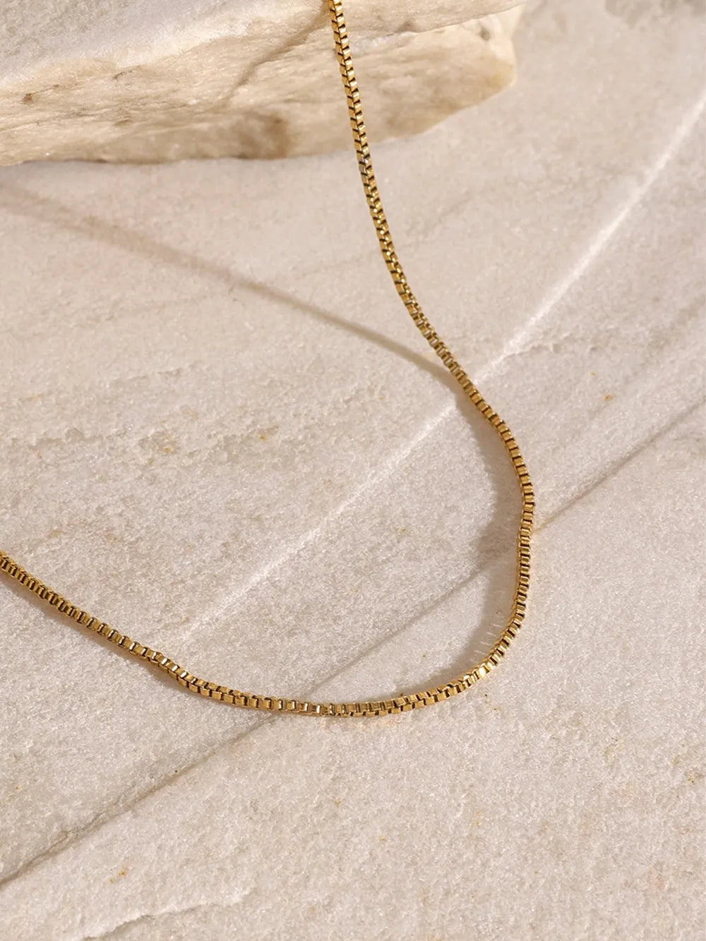 18K gold-plated three-layered cross necklace with intricate details, layered design, and chain links, showcasing elegance and craftsmanship.