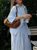 Trendsi loungewear set with button-up shirt and drawstring pants, featuring comfortable casual fabric in neutral tones.