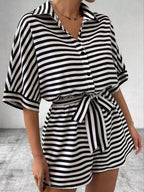 Striped button-up belted romper jumpsuit from Trendsi, featuring a stylish design with a waist belt and short sleeves.