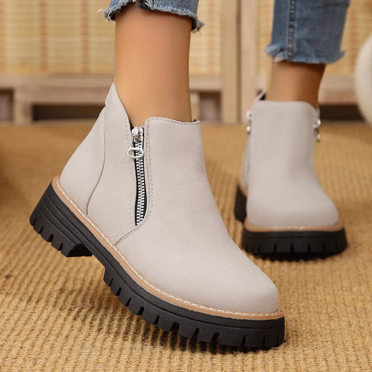 Black ankle boots with zipper accent and chunky heel, stylish footwear by Trendsi featuring side zipper detail.