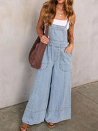 Women's relaxed fit wide-leg denim overalls made from comfortable cotton blend, featuring adjustable straps and spacious pockets.