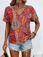 Bohemian paisley print V-neck short sleeve T-shirt by Trendsi, featuring colorful paisley pattern and relaxed fit.