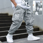 Men’s multi-pocket drawstring cargo pants in streetwear style, featuring multiple pockets and a comfortable drawstring waist.