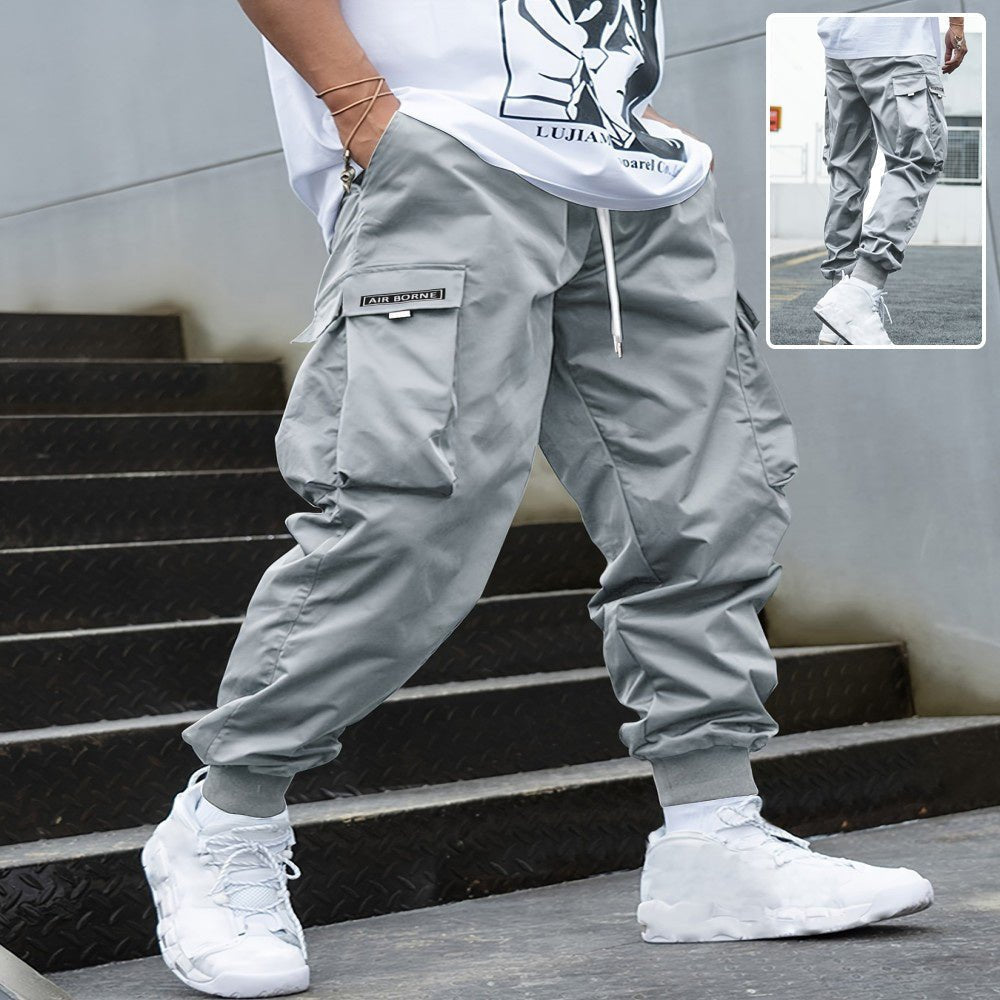 Men’s multi-pocket drawstring cargo pants in streetwear style, featuring multiple pockets and a comfortable drawstring waist.