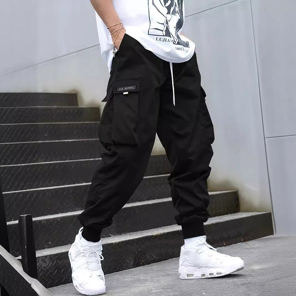 Men's multi-pocket drawstring cargo pants in streetwear style by Plush Fashion Hub, featuring multiple pockets and a relaxed fit.