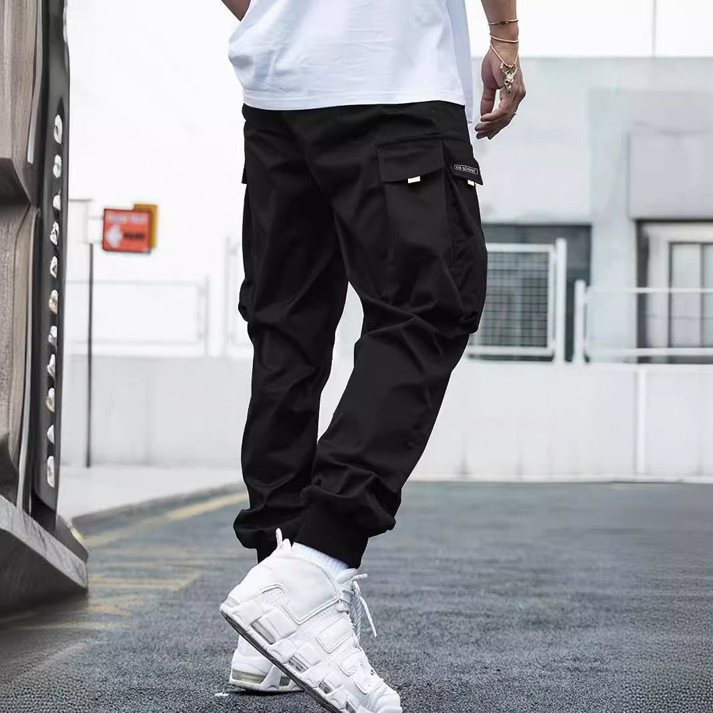 Men's multi-pocket drawstring cargo pants in streetwear style by Plush Fashion Hub, featuring multiple pockets and a relaxed fit.