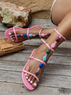 Women's adjustable ankle strap flat sandals with buckle, made from comfortable vegan leather, featuring multiple straps for a stylish fit.
