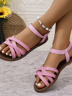 Women's open-toe cross-strap flat sandals in faux leather, trendy and comfortable shoes by Trendsi.