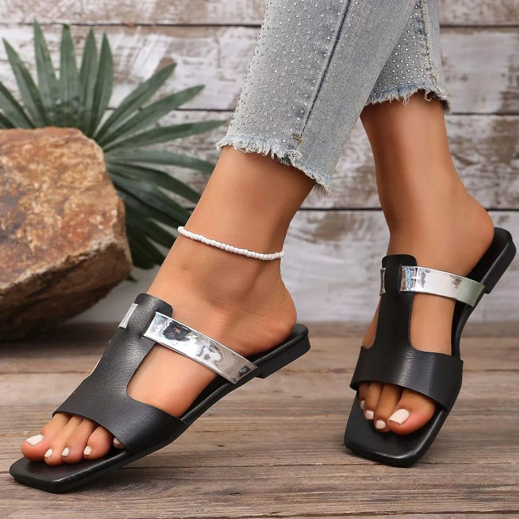 Women's open-toe vegan leather flat sandals with a chic design, featuring a comfortable footbed and stylish straps.