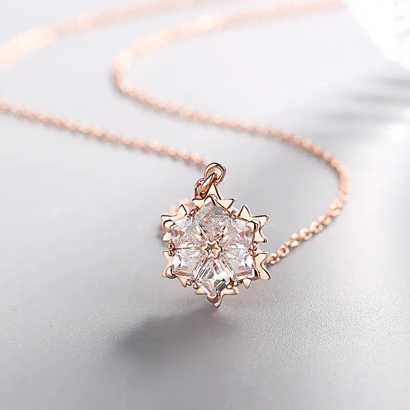 Silver snowflake necklace with diamond pendant, featuring a delicate chain and sparkling gemstone detail.