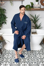 Absorbent, lightweight men's waffle spa bathrobe by Plush Fashion Hub, shown hanging on a hook with a soft, textured fabric.