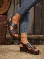 Women's studded PU leather wedge sandals with ankle straps, featuring a casual summer style and comfortable wedge heel.