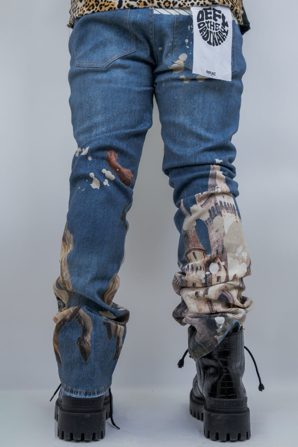 Purple pair of ARMOR JEANS RM203SK graphic printed stacked jeans displayed on a mannequin.