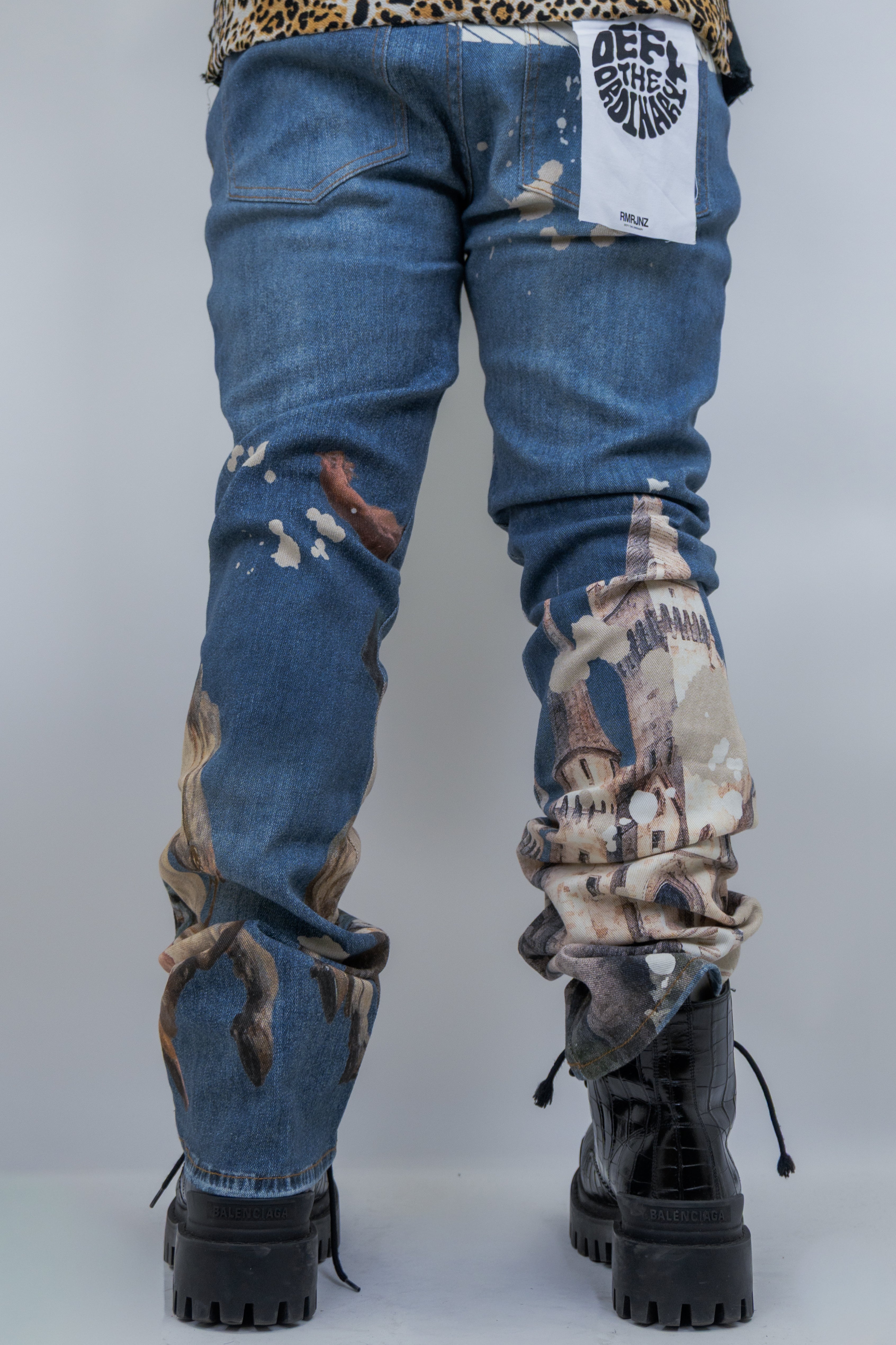 Purple pair of ARMOR JEANS RM203SK graphic printed stacked jeans displayed on a mannequin.