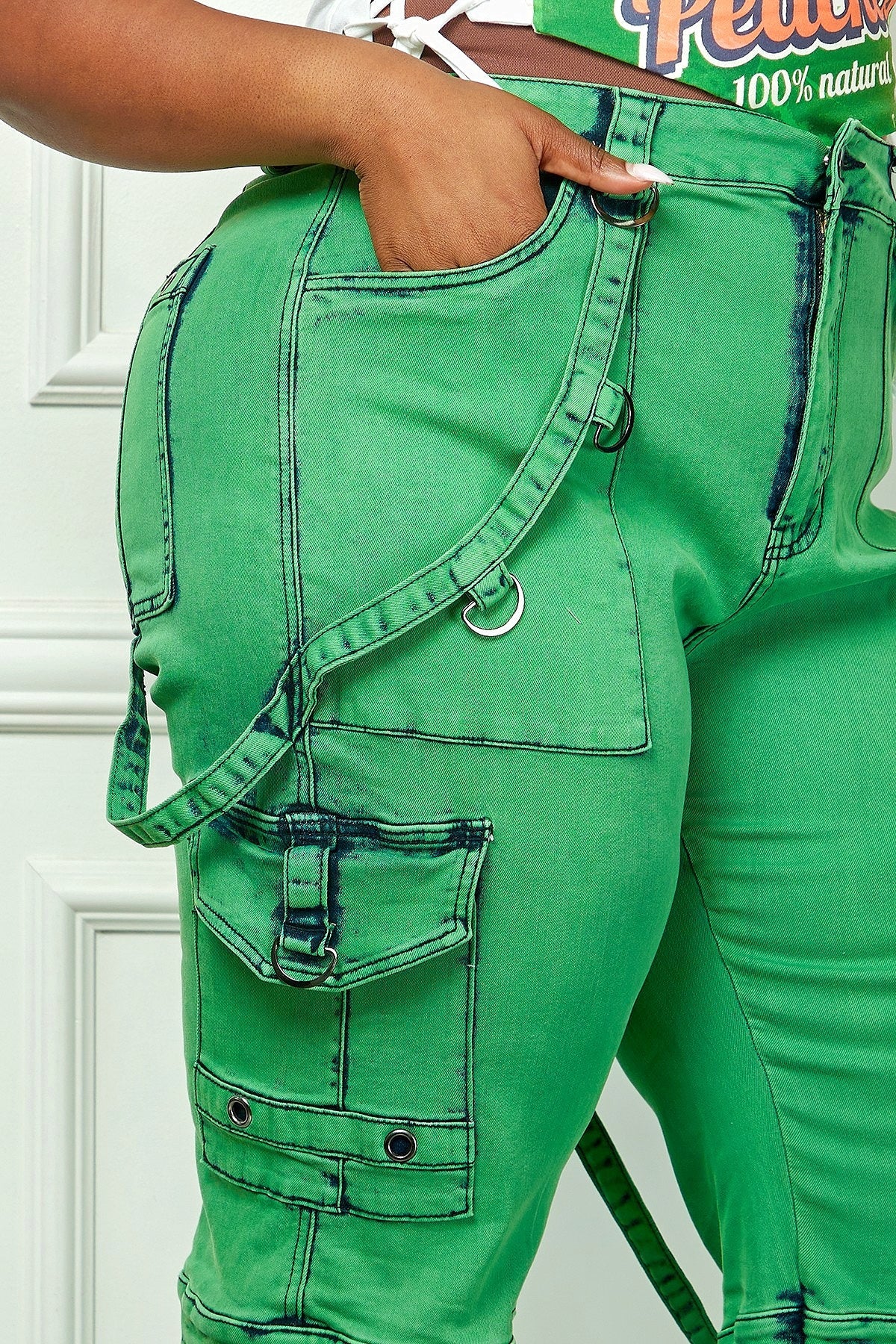 Plus size green denim cargo pants by Fasheabe featuring utility pockets and relaxed fit, styled on a model.