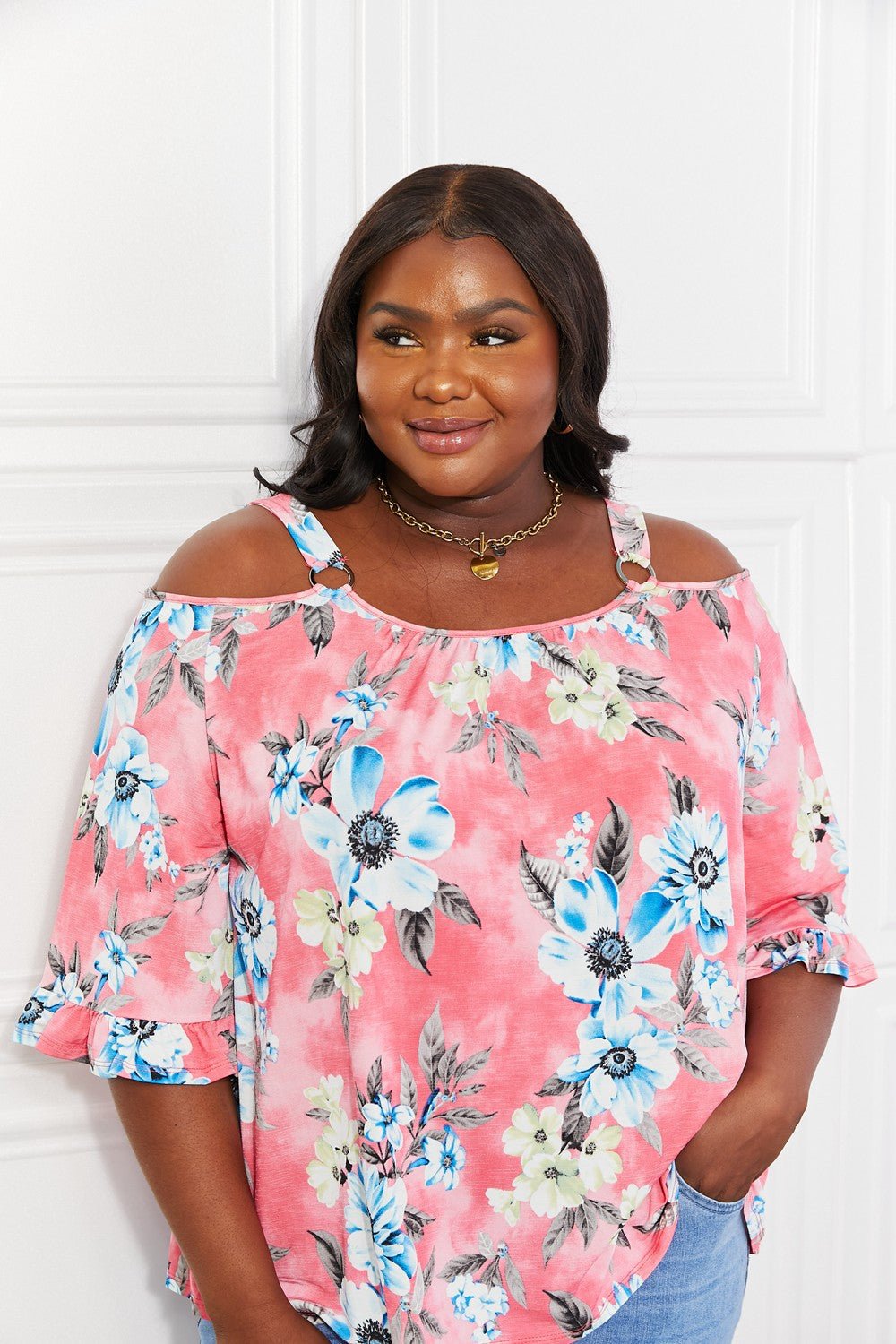 Floral cold-shoulder women's top with three-quarter sleeves and metal ring details, stylish Trendsi women's apparel.