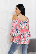 Women’s floral cold-shoulder top with three-quarter sleeves and metal ring details, stylish trendy women’s apparel.