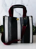 Plush Fashion Hub stripe tote bag with black and white striped pattern, featuring sturdy handles and spacious interior.