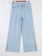 Trendsi studded wide-leg jeans with frayed hem, side slits, and distressed details, styled with a casual, trendy look.