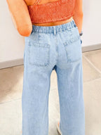 Pair of trendy studded wide-leg jeans with frayed hem and side slits, showcasing a fashionable casual denim look.