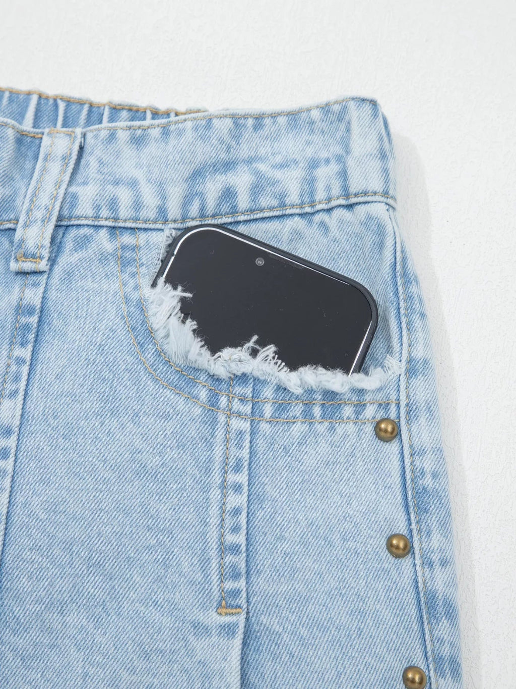 Trendsi studded wide-leg jeans with frayed hem and side slits, showcasing a trendy denim style with added embellishments.