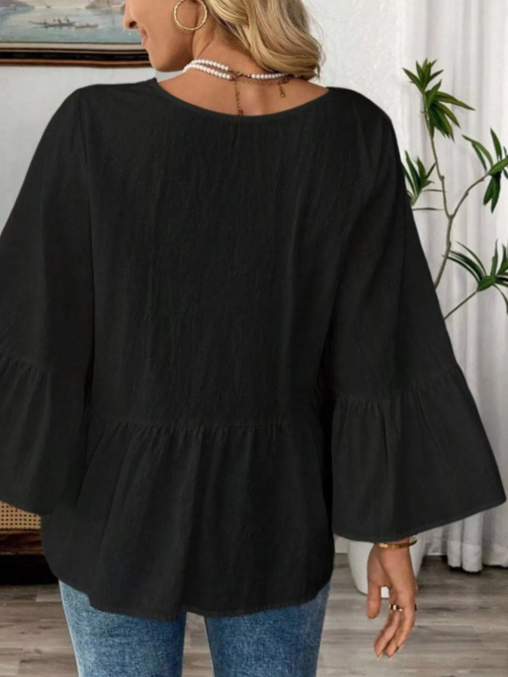 Women's 100% cotton V-neck bell sleeve blouse from Trendsi, featuring a relaxed fit and stylish bell sleeves.
