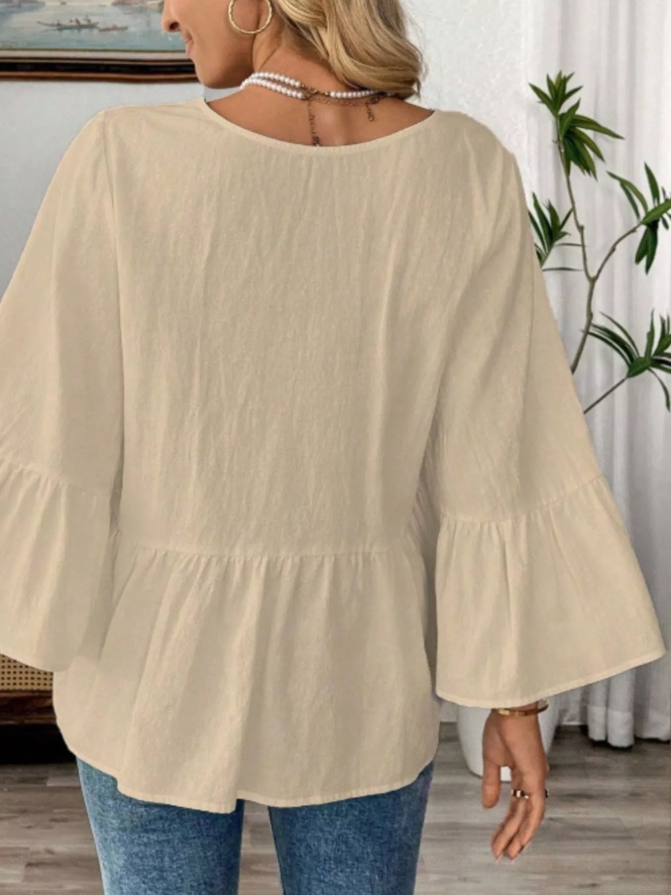 Women's 100% cotton V-neck bell sleeve blouse by Trendsi, featuring a relaxed fit and chic, effortless style.