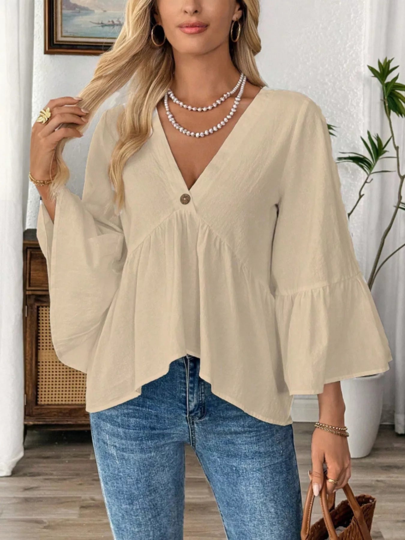 Women's 100% cotton V-neck bell sleeve blouse with a relaxed fit, showcasing effortless chic style and trendy bell sleeve design.