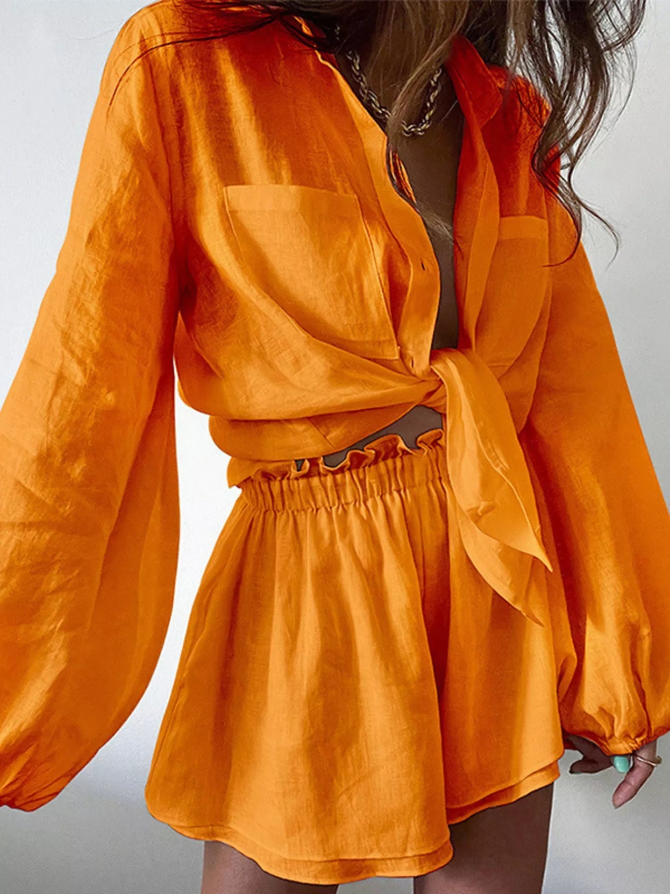 Women's long sleeve button-up shirt and shorts lounge set by Trendsi, made of soft fabric, perfect for casual or relaxation wear.