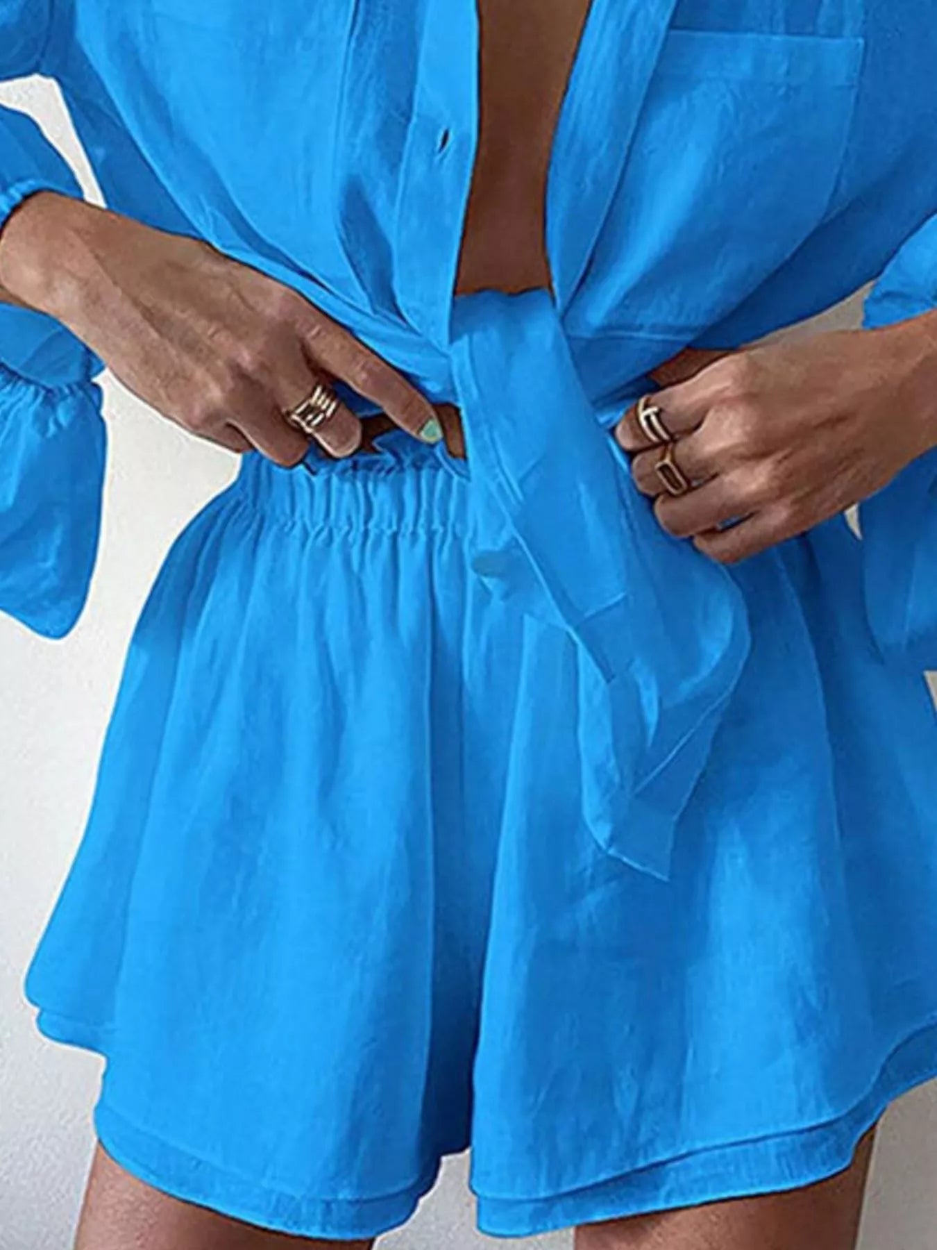Women's long sleeve button-up shirt and shorts lounge set by Trendsi, comfortable two-piece clothing set for relaxed wear.