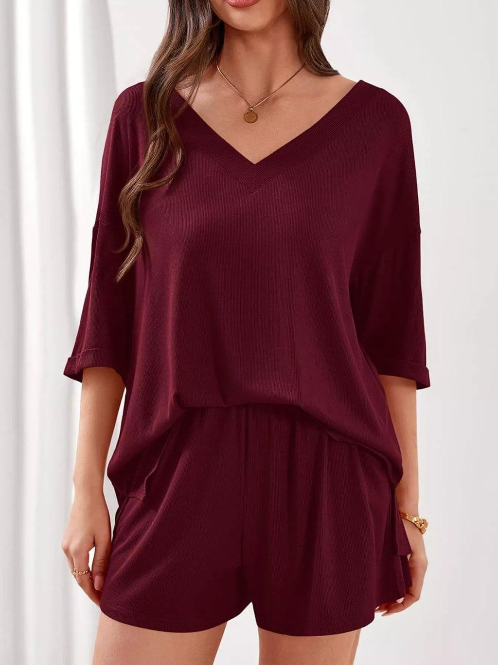 Women's casual V-neck top and shorts set by Trendsi, solid color two-piece outfit, perfect for relaxed summer wear.