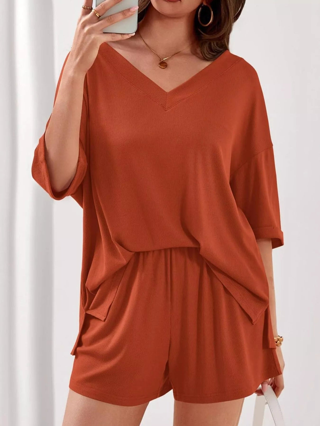 Women’s casual V-neck top and shorts set in solid color, trendy two-piece outfit from Trendsi, perfect for relaxed everyday wear.