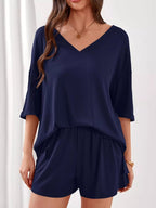 Women's casual V-neck top and shorts set by Trendsi, solid color two-piece outfit, perfect for relaxed everyday wear.
