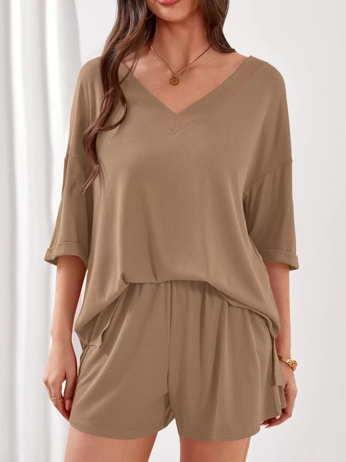 Women's casual V-neck top and shorts set by Trendsi, featuring a solid color two-piece outfit perfect for relaxed, everyday wear.