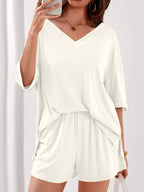 Women's casual V-neck top and shorts set in solid color, trendy two-piece outfit by Trendsi, perfect for relaxed everyday wear.