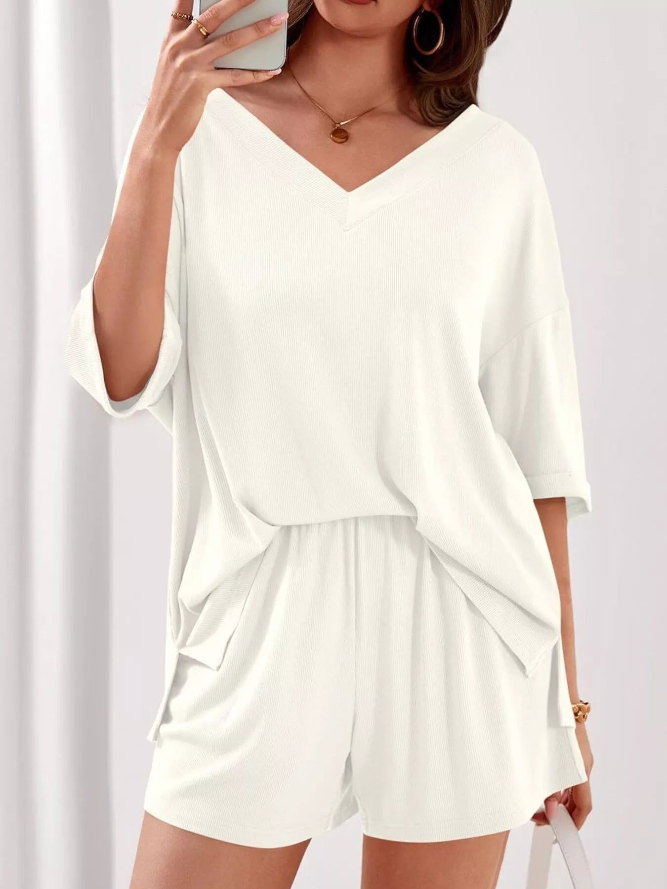 Women's casual V-neck top and shorts set in solid color, trendy two-piece outfit by Trendsi, perfect for relaxed everyday wear.
