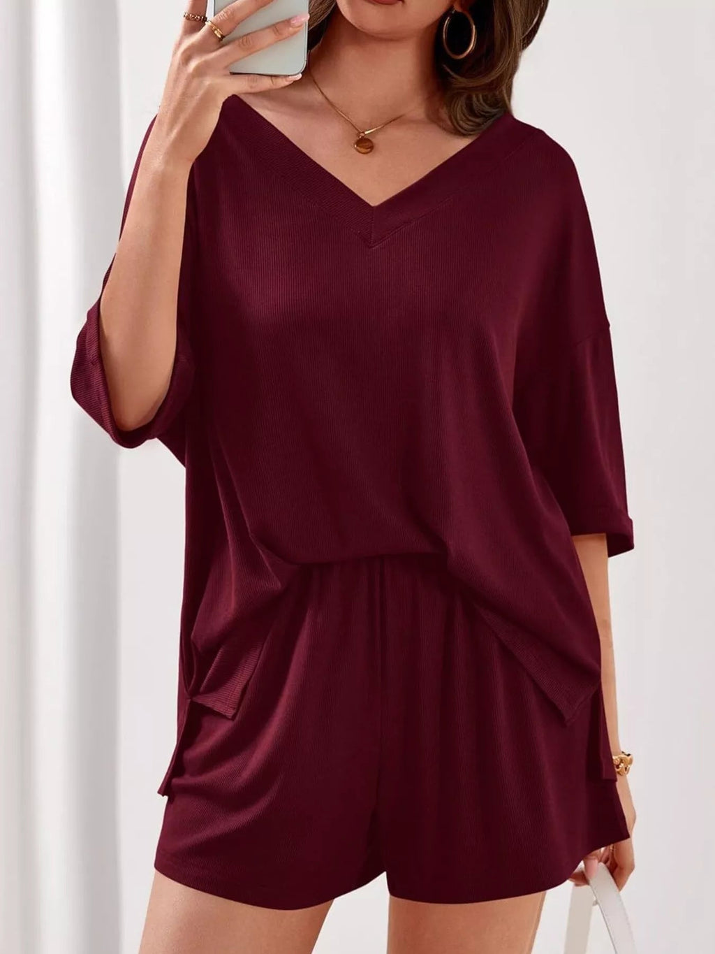 Women's casual V-neck top and shorts set in solid color, trendy two-piece outfit by Trendsi, perfect for relaxed everyday wear.