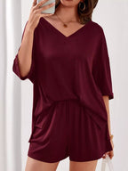 Women's casual V-neck top and shorts set in solid color, trendy two-piece outfit by Trendsi, perfect for relaxed everyday wear.