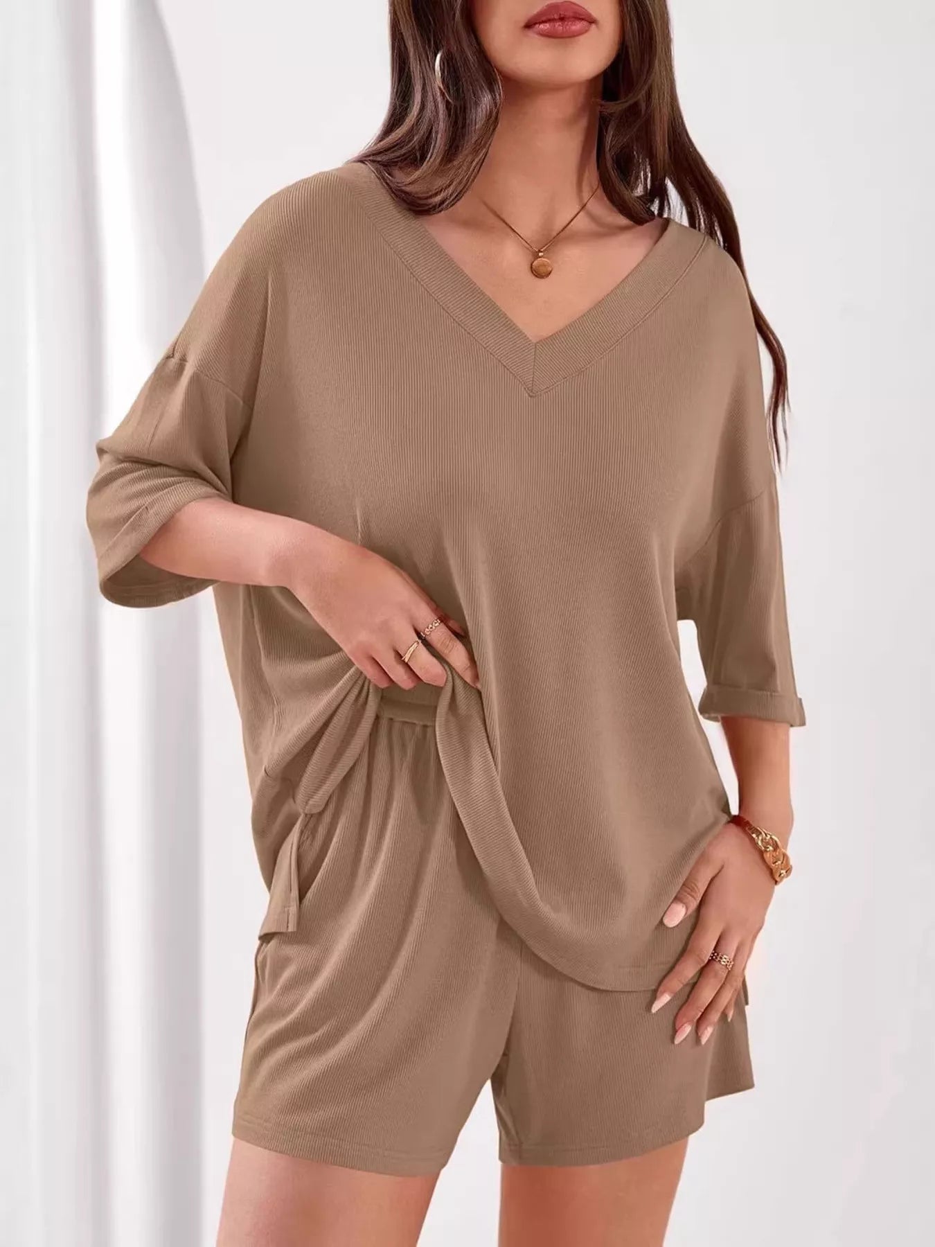 Women's casual V-neck top and shorts set by Trendsi, solid color two-piece outfit, perfect for relaxed and stylish summer wear.