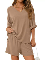 Women's casual V-neck top and shorts set in solid color, trendy two-piece outfits by Trendsi. Perfect for relaxed, stylish wear.