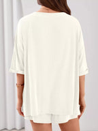 Women's casual V-neck top and shorts set by Trendsi, solid color two-piece outfit, perfect for relaxed and stylish everyday wear.